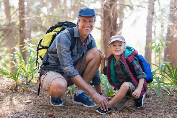 Padre legatura lacci per il figlio nella foresta — Foto Stock