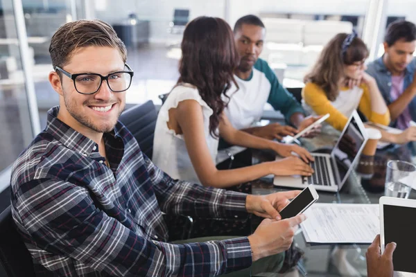 Hombre de negocios usando el teléfono móvil en el escritorio — Foto de Stock