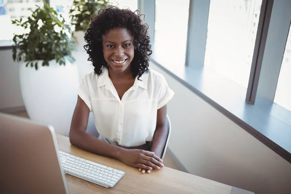 Exécutif souriant assis au bureau — Photo