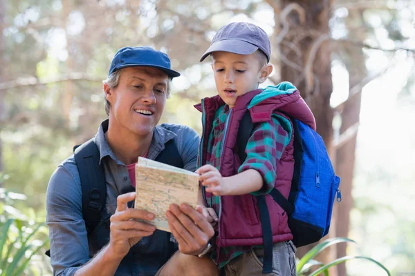 Man and boy reading map in forest — Stock Photo, Image