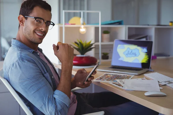 Businessman using phone at creative office — Stock Photo, Image