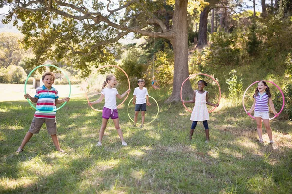 Gruppe fröhlicher Freunde spielt mit Hula-Hoop-Reifen — Stockfoto