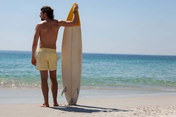 Surfista com prancha olhando para o mar — Fotografia de Stock
