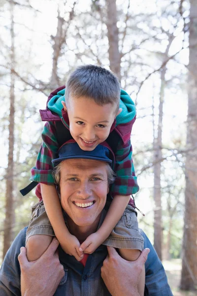 Хлопчик сидить на плечах батька в лісі — стокове фото