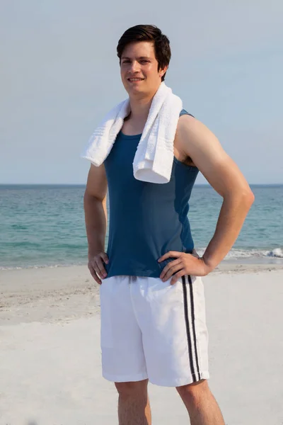 Man op strand met handdoek rond zijn nek — Stockfoto