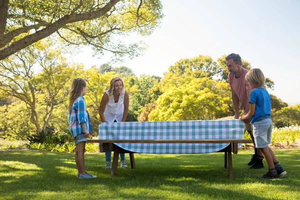 Family spreading the tablecloth on table — Stock Photo, Image