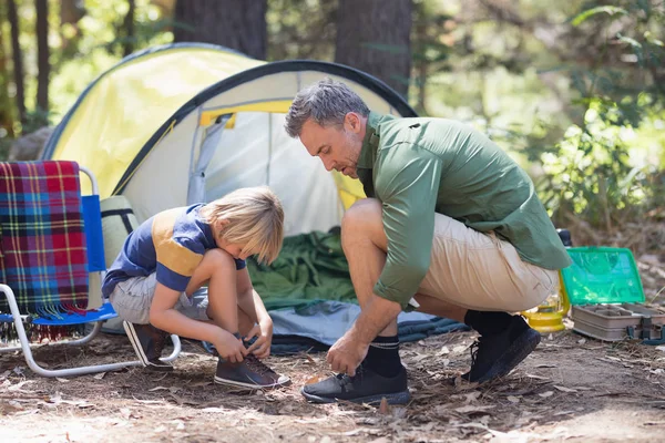 Padre e figlio legano lacci da scarpe da tenda al campeggio — Foto Stock