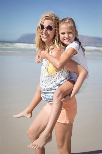 母亲捎带她女儿在海滩 — 图库照片