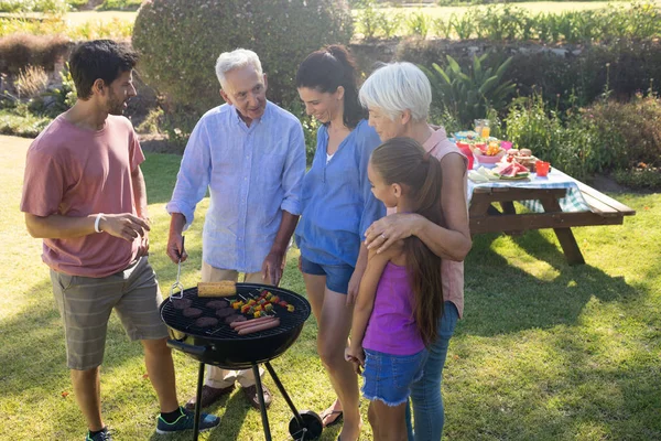 Famiglia parlando durante la preparazione del barbecue — Foto Stock