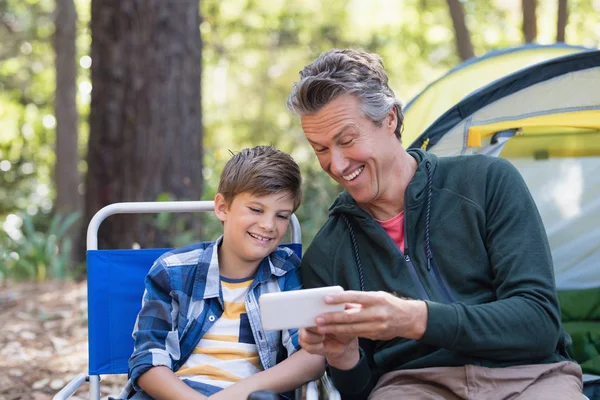 Vader tonen mobiele aan zoon in bos — Stockfoto