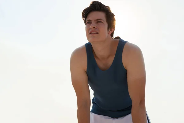 Man taking break after jogging on beach — Stock Photo, Image