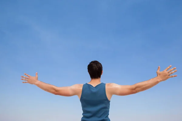 Man op strand met uitgestrekte armen — Stockfoto