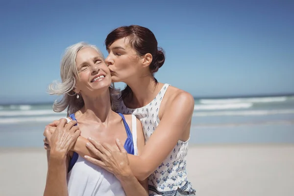 Mujer besando a su madre en la playa —  Fotos de Stock