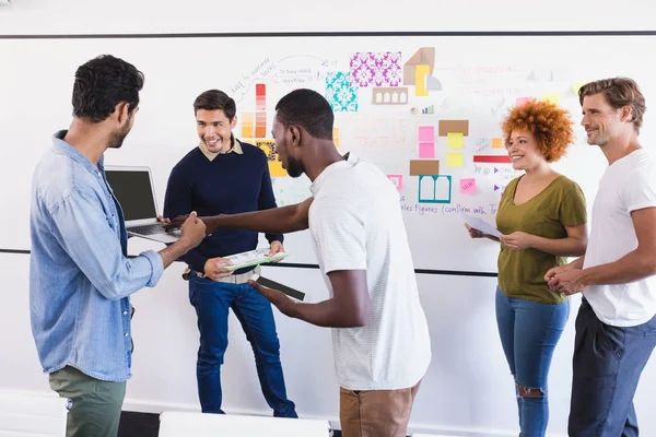 Business colleagues while standing against whiteboard — Stock Photo, Image