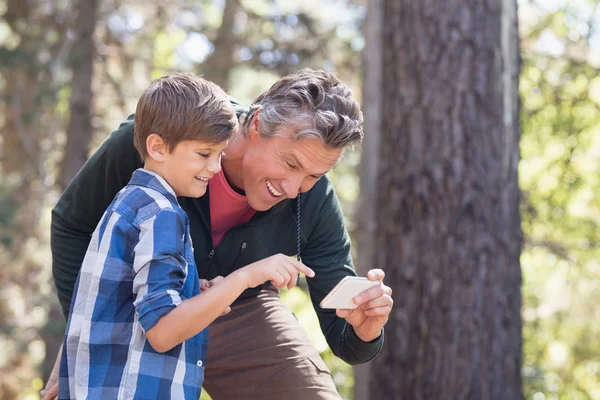 Baba ve oğul ormanda istimal hareket eden telefon — Stok fotoğraf