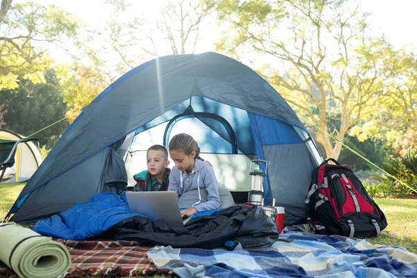 Kinder nutzen Laptop im Zelt — Stockfoto