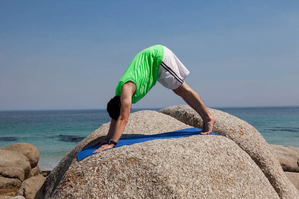 Uomo che esegue yoga su roccia — Foto Stock