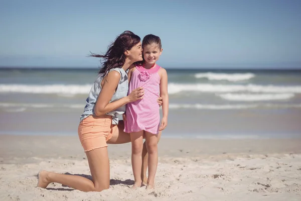 Mère embrasser sa fille à la plage — Photo