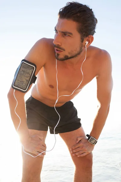 Homme prendre une pause après avoir fait du jogging sur la plage — Photo