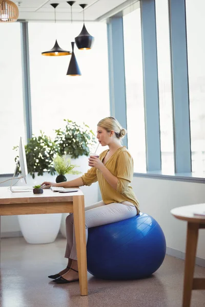 Výkonný sedí na fitness míč při práci — Stock fotografie