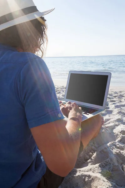 Man met laptop op het strand — Stockfoto
