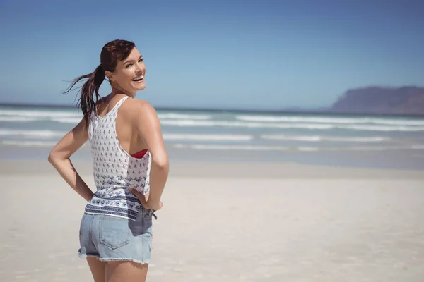 Donna con le mani sul fianco in spiaggia — Foto Stock