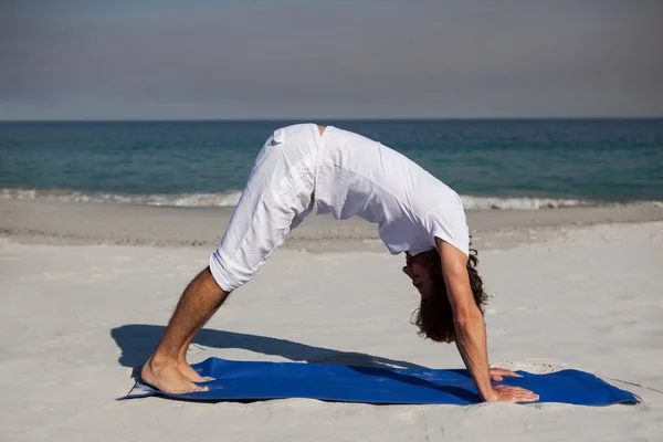 Uomo che esegue yoga in spiaggia — Foto Stock