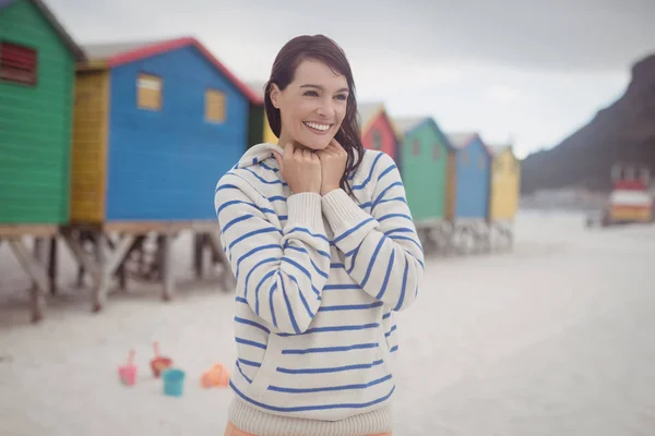 Sonriente mujer de pie en la playa — Foto de Stock