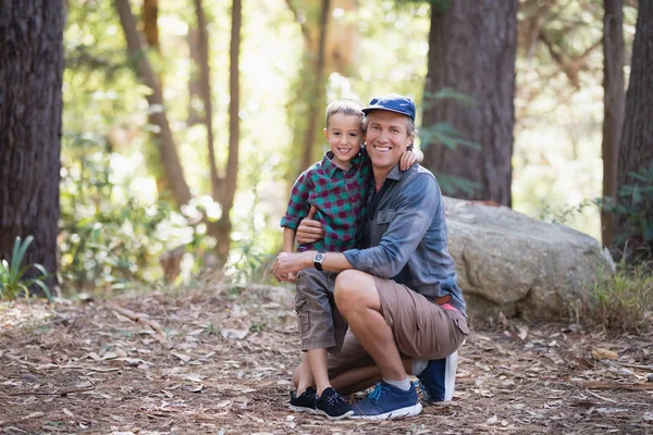Sonriente padre e hijo en el bosque —  Fotos de Stock