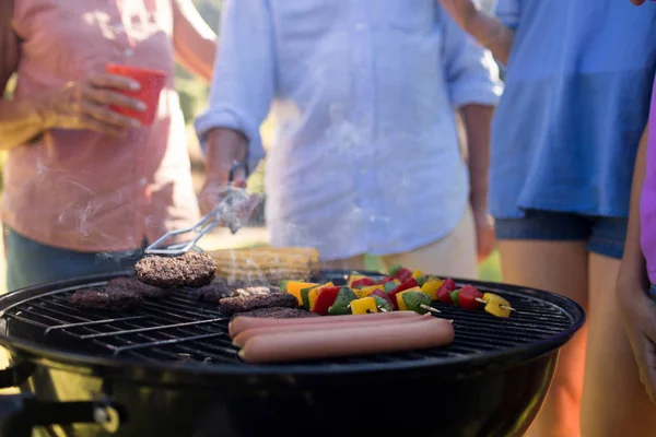 Familjen grillning pastejer, korvar och grönsaker — Stockfoto