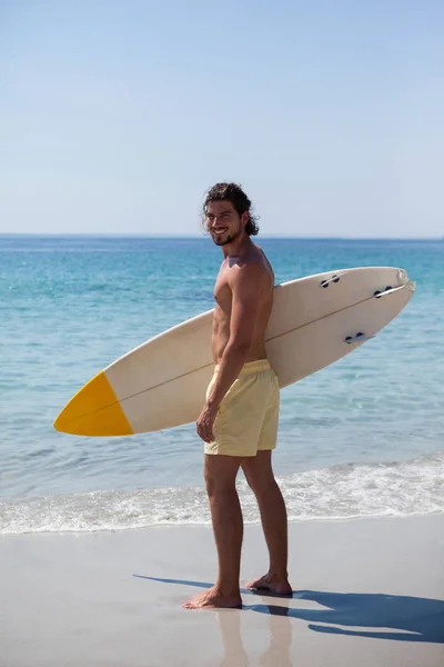 Surfista com prancha em pé na costa da praia — Fotografia de Stock