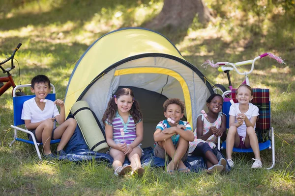 Children sitting outside tent at campsite — Stock Photo, Image