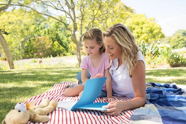 Mor och dotter läsa bok i parken — Stockfoto