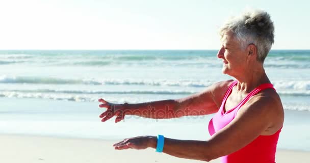 Mulher sênior fazendo exercício na praia — Vídeo de Stock