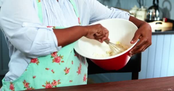 Mujer mayor mezclando harina en un tazón — Vídeos de Stock