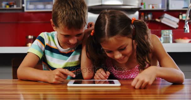 Irmãos usando tablet digital na cozinha — Vídeo de Stock