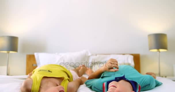 Siblings relaxing on bed in bedroom — Stock Video