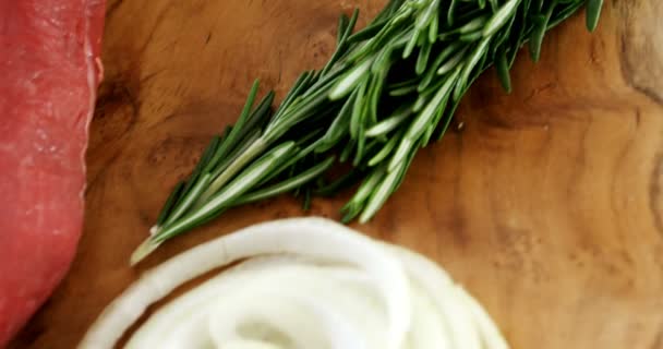 Rauw vlees en ingrediënten op een houten bord — Stockvideo