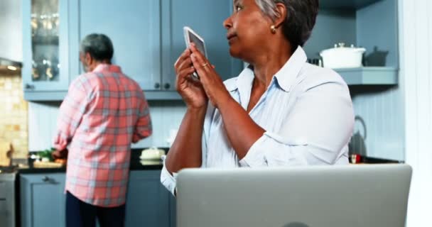 Senior paar praten op mobiele telefoon in de keuken — Stockvideo