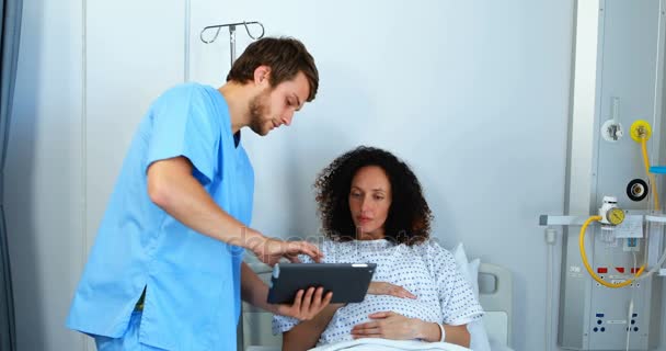 デジタル タブレットの妊娠中の女性に医療レポートを示す医師 — ストック動画