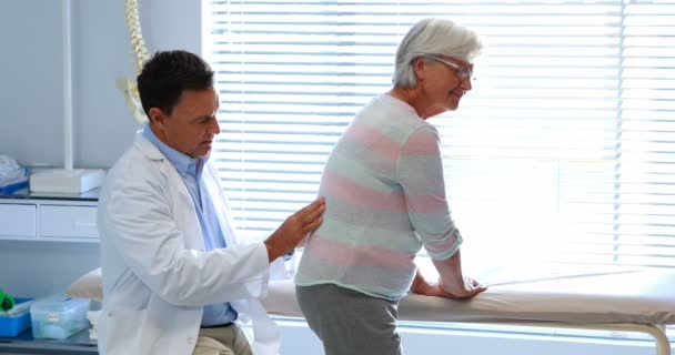 Физиотерапевт делает массаж спины пожилым пациентам — стоковое видео