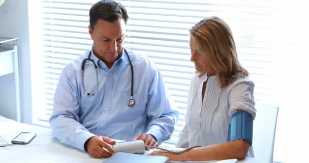 Dokter interactie met patiënt terwijl het controleren van bloeddruk — Stockvideo