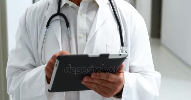 Uśmiechający się lekarz za pomocą cyfrowego tabletu w korytarzu — Wideo stockowe