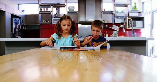 Hermanos haciendo sus deberes en la cocina — Vídeos de Stock