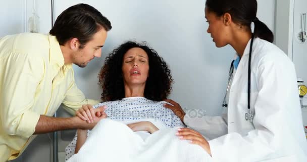 Médico y hombre reconfortando a la mujer embarazada en la sala — Vídeo de stock