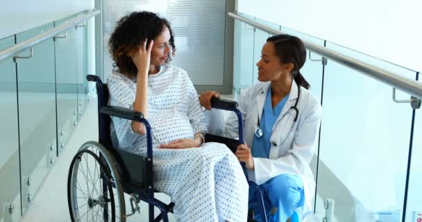Médico interactuando con la mujer embarazada en el pasillo — Vídeo de stock