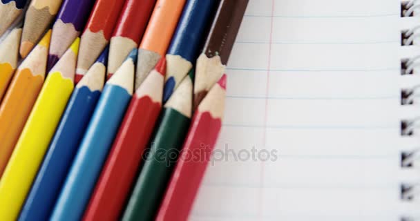 Lápis coloridos dispostos em padrão de bloqueio no fundo branco — Vídeo de Stock