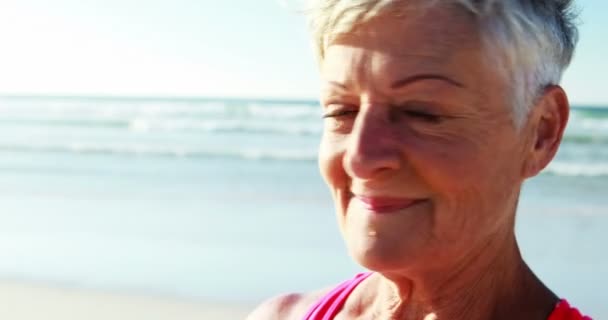 Sorrindo mulher sênior de pé na praia — Vídeo de Stock