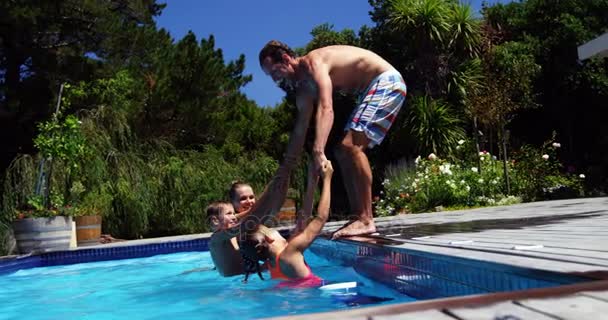 Mãe e filhos puxando pai na piscina — Vídeo de Stock