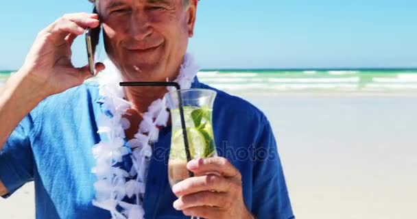 Homme âgé parlant sur un téléphone portable sur le téléphone à la plage — Video